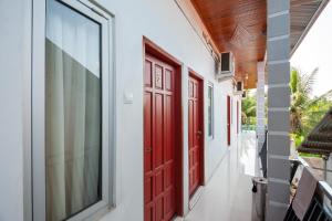 SolokRedDoorz Syariah near RS Tentara Solok的门廊,门廊上装有红色门