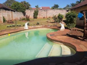 恩潘盖尼Kwesethu Guesthouse的院子里有两只狗的游泳池