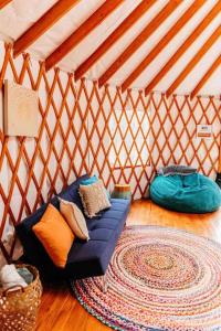 彭延Heated & AC Yurt的蒙古包内的一个蓝色沙发的房间