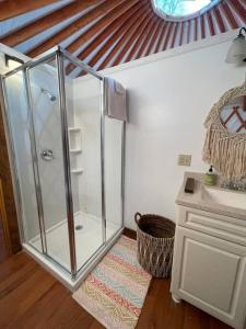 彭延Heated & AC Yurt的一间带玻璃淋浴和水槽的浴室