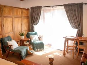 斯韦伦丹Place of Sonlight的客厅配有椅子和大窗户