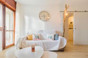 莫格罗Apartamento mogro playa的一间墙上挂有时钟的床的房间