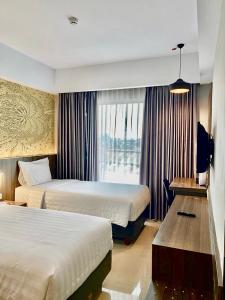日惹Unisi Hotel Malioboro - Jogja Syariah的酒店客房设有两张床和窗户。