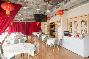 香港長洲華威酒店的一间设有白色桌椅和红色窗帘的餐厅