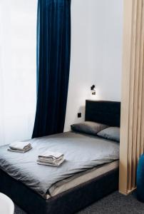 乌日霍罗德RESA apart - нові smart-квартири біля річки的一张带蓝色窗帘的床和两条毛巾