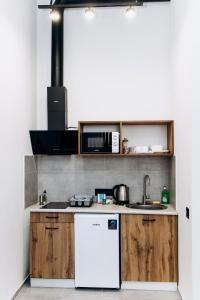 乌日霍罗德RESA apart - нові smart-квартири біля річки的厨房配有木制橱柜和白色冰箱。