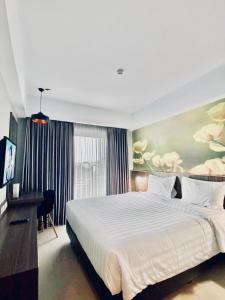 日惹Unisi Hotel Malioboro - Jogja Syariah的卧室配有一张白色大床和一张书桌