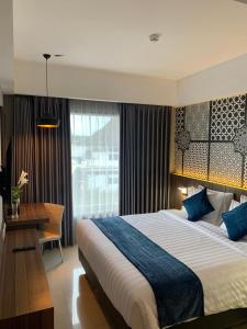 日惹Unisi Hotel Malioboro - Jogja Syariah的酒店客房设有一张大床和一张书桌。