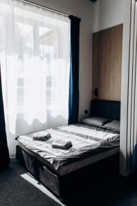 乌日霍罗德RESA apart - нові smart-квартири біля річки的窗户间里一张带两条毛巾的床