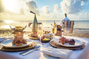 蒙巴萨萨罗瓦白沙海滩度假Spa酒店的海滩上的餐桌,包括食物和饮料