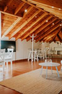 托雷德尔马尔Mares - Atic的客房设有木制天花板、白色椅子和桌子。
