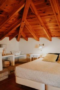 托雷德尔马尔Mares - Atic的一间卧室设有一张大床和木制天花板。