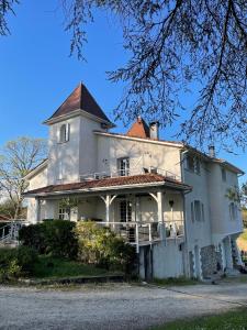 Saint-Barthélémy-dʼAgenaisDOMAINE DES PEYRIES - Chambres et table d'hôtes的一座大型白色房屋,顶部有塔楼