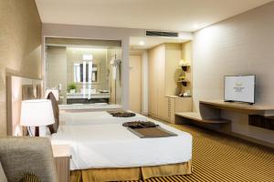 芽庄Muong Thanh Luxury Khanh Hoa的酒店客房,设有两张床和镜子