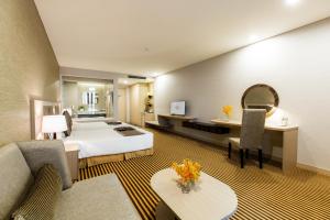 芽庄Muong Thanh Luxury Khanh Hoa的配有一张床和一张书桌的酒店客房