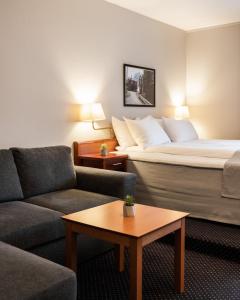 莫舍恩Frøken Skjolds Hotel Lyngengården的酒店客房配有床、沙发和桌子。