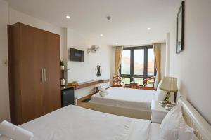 岘港SeaColor Beachstay Danang Hotel by Haviland的酒店客房设有两张床和窗户。