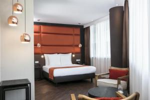 阿姆斯特丹竞技场塔阿姆斯特丹假日酒店的配有一张床和一把椅子的酒店客房