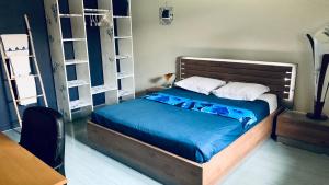 厄唐萨雷Le Dodo Salé的一间卧室配有一张带蓝色床单和白色枕头的床。