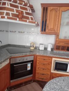 巴尔韦尔德Mi Piriposa的厨房配有木制橱柜和炉灶烤箱。