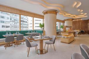 香港香港铜锣湾皇冠假日酒店的餐厅设有桌椅和大窗户。
