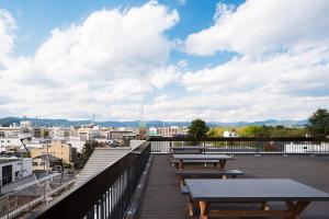 京都RAKURO Kyoto by THE SHARE HOTELS的一个带长椅的市景甲板