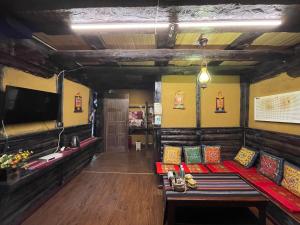 香格里拉香格里拉天依阁客栈的一间配备有沙发、电视和沙发的客房