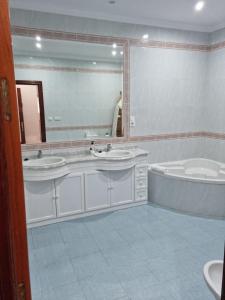 阿尔科斯-德拉弗龙特拉Piso Levante的浴室配有2个盥洗盆、浴缸和大镜子