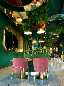 比尔什托纳斯Ego SPA的一间设有粉红色椅子和绿色墙壁的餐厅