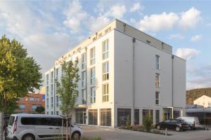 海德堡acora Heidelberg Living the City - Apartments的前面有一辆货车停在白色建筑前