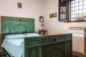 圣奎里科-多尔恰La Moiana的一间卧室设有一张绿色的床和一个窗户。