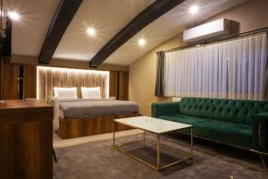 BakanlıklarAnatolia Luxury Hotel的酒店客房,设有一张床铺和一张绿色沙发