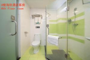 广州潮漫酒店(广州石井城市广场小坪地铁站店)的一间带卫生间和玻璃淋浴间的浴室