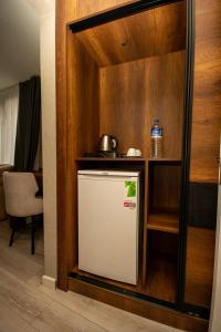 BakanlıklarAnatolia Luxury Hotel的带架子的厨房里的小冰箱