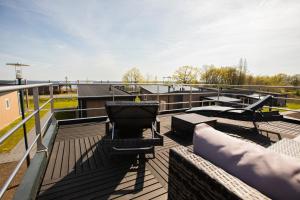 Große MühleLodgepark Goitzsche GmbH的屋顶甲板上设有烧烤架和椅子