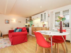 ColebrookePlum Cottage的厨房以及带桌子和红色椅子的客厅。