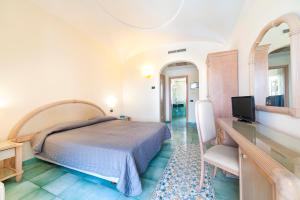伊斯基亚Hotel Terme Don Pepe的一间卧室配有一张床和一张书桌及电视