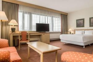 鹿特丹鹿特丹亚特兰大NH酒店的配有一张床和一张书桌的酒店客房