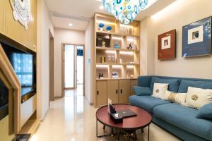 广州Cloud Land Apartment 翡翠华庭的客厅配有蓝色的沙发和桌子