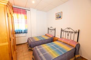 阿罗约弗里奥Alojamiento Rural Arco Iris的一间卧室,配有两张床