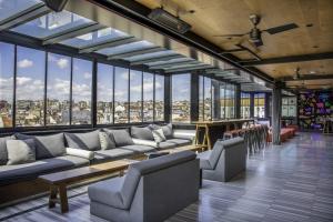 伊斯坦布尔Wabi Sabi Hostel Istanbul的大型客房设有沙发、桌子和窗户。