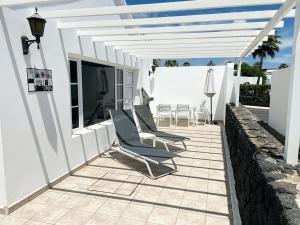 卡门港Casas Maribel Pocillos - No Pool - Sin Piscina的白色建筑中带桌椅的庭院