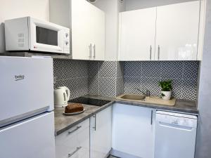 弗瓦迪斯瓦沃沃Apartamenty Jasny Brzeg的白色的厨房配有白色的橱柜和微波炉