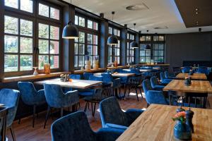 不莱梅ATLANTIC Hotel Landgut Horn的餐厅设有木桌和蓝色椅子