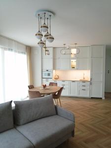 格但斯克Gdańsk Porto Apartments的客厅配有沙发和桌子