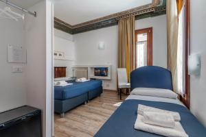 威尼斯艾多莫里酒店的一间设有两张床和蓝色沙发的房间