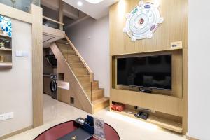 广州Cloud Land Apartment 翡翠华庭的客厅设有大电视和楼梯。