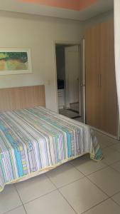 皮拉伊河畔巴拉Flat Village - Aldeia das Águas的一间卧室配有一张床,床上有条纹毯子