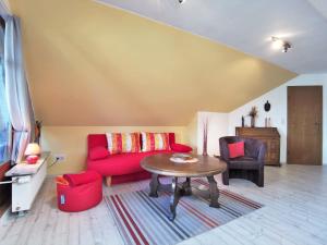SilberstedtFerienwohnung Thiessen的客厅配有红色的沙发和桌子