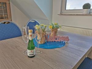 SilberstedtFerienwohnung Thiessen的一张桌子,上面放着两杯酒和一瓶葡萄酒